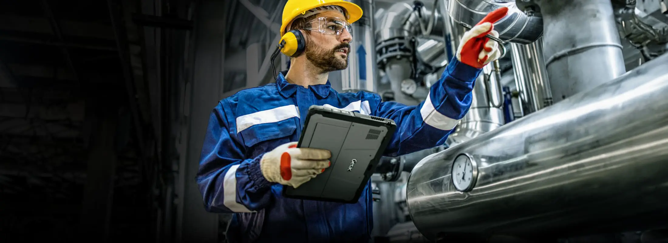 Inginer care folosește tableta ATEX Getac K120-EX într-o instalație industrială